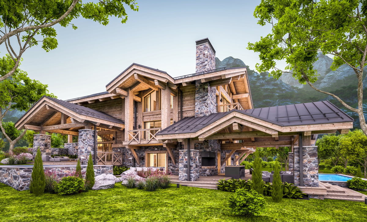 Modern mountain chalet with pool, massive timber beams, and beautiful forest mountain backdrop at sunset